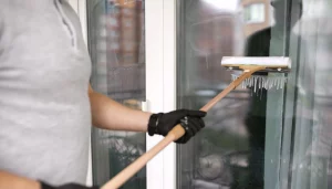 Mitarbeiter bei der Glas- und Fensterreinigung mit Abzieher – ALB Objektservice Reutlingen, Tübingen & Stuttgart