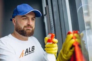Mitarbeiter von ALB Objektservice bei der Fensterreinigung mit Sprühflasche und Tuch – professionelle Glas- & Fensterpflege in Reutlingen, Tübingen & Stuttgart