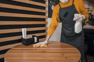 Mitarbeiter von ALB Objektservice reinigt Tisch in einem Restaurant – professionelle Gastronomiereinigung und Hygieneservice für Gewerbebetriebe in Reutlingen, Tübingen & Stuttgart